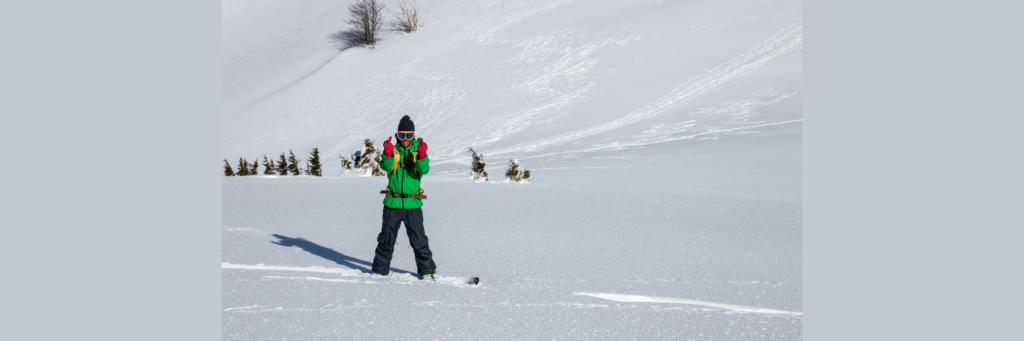 man on ski hill giving the finger