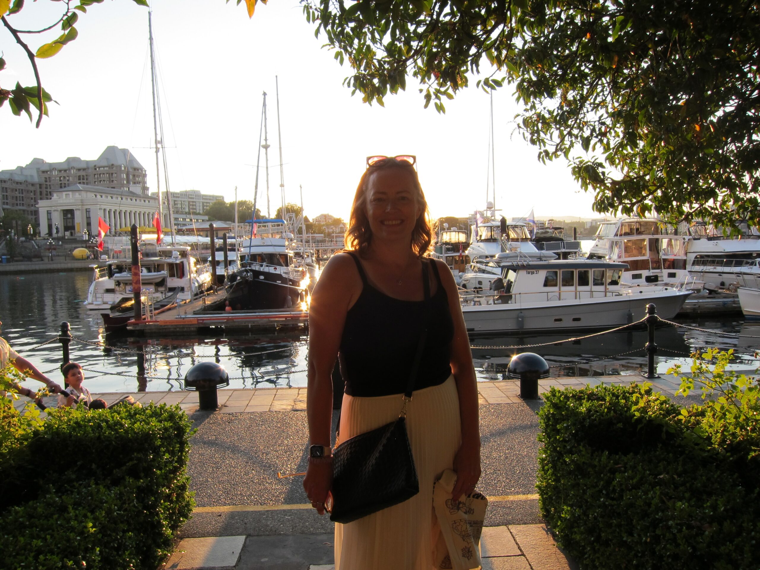 Donita Fowler smiling by the harbour at sunset